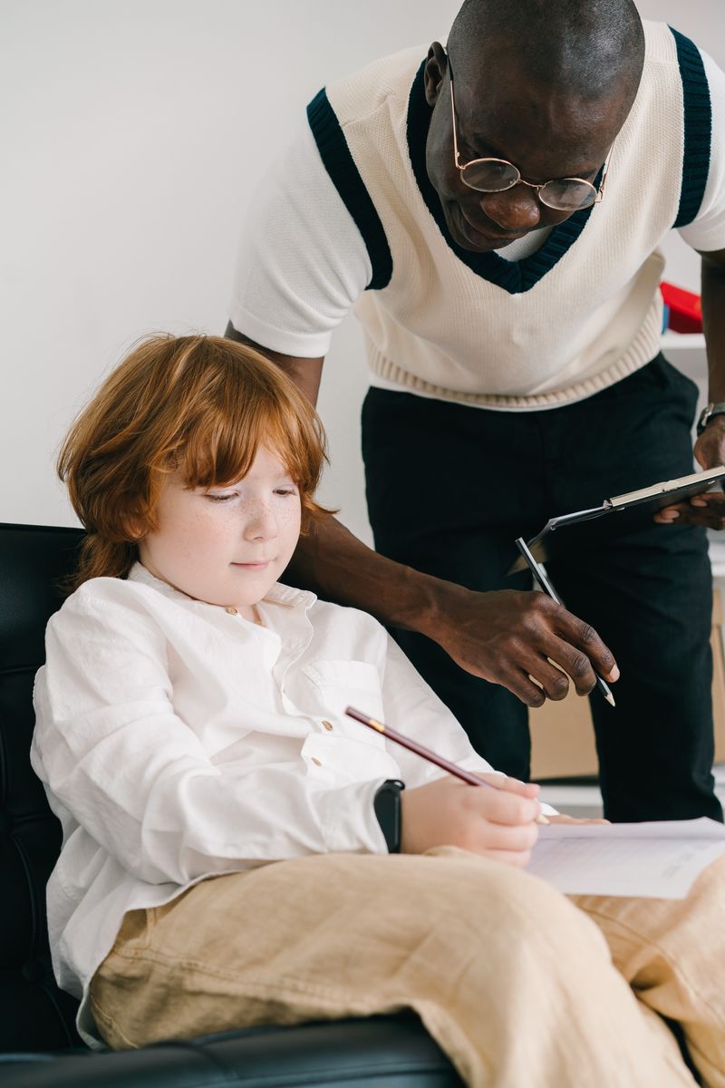 A tutor sitting beside a learner, working through an exercise book together